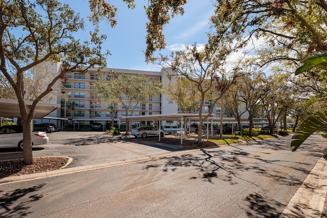 view of building exterior featuring covered and uncovered parking