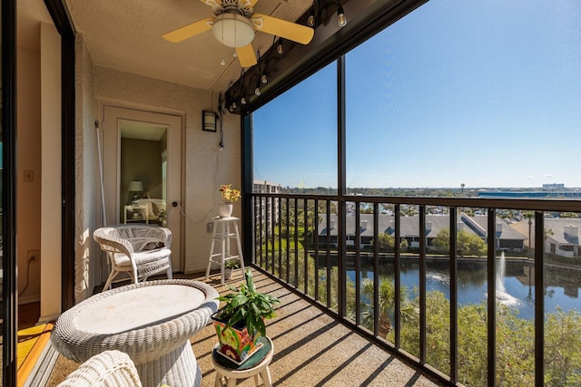 balcony with a ceiling fan and a water view