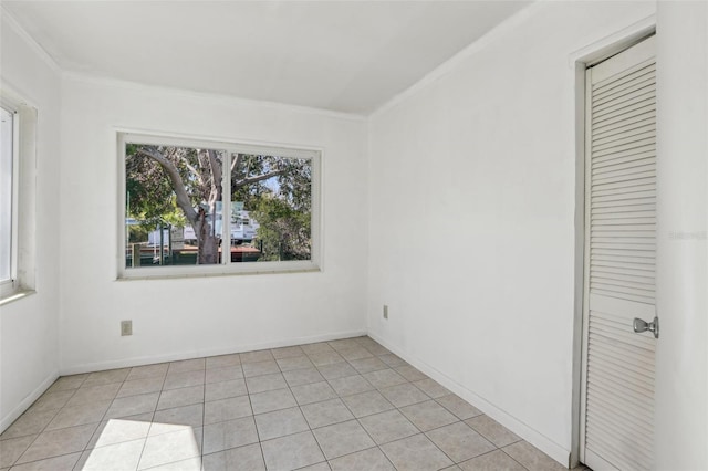 unfurnished room with light tile patterned floors, baseboards, and crown molding