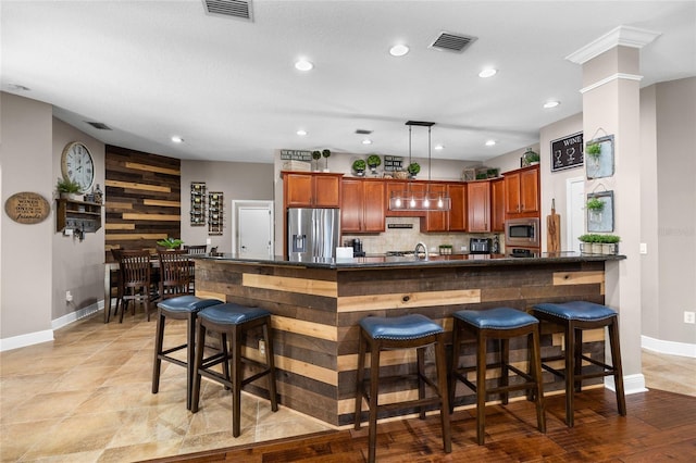 kitchen featuring appliances with stainless steel finishes, dark countertops, visible vents, and backsplash