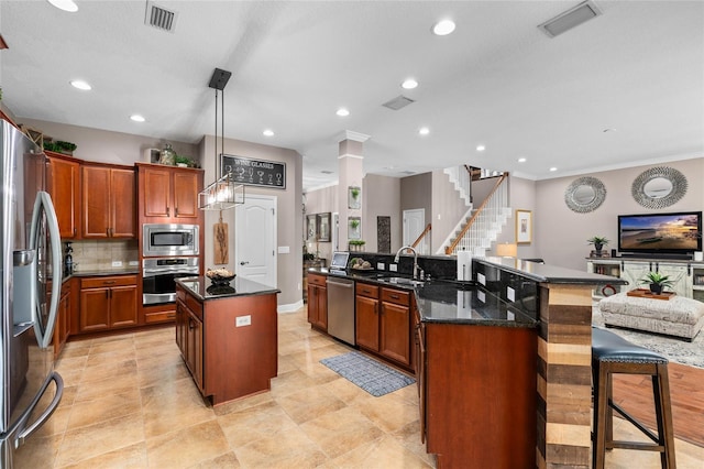 kitchen with stainless steel appliances, a large island, a sink, and visible vents