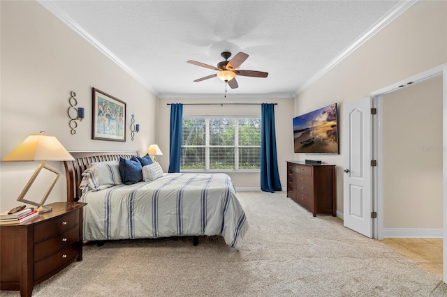 bedroom featuring light colored carpet, crown molding, a textured ceiling, and baseboards