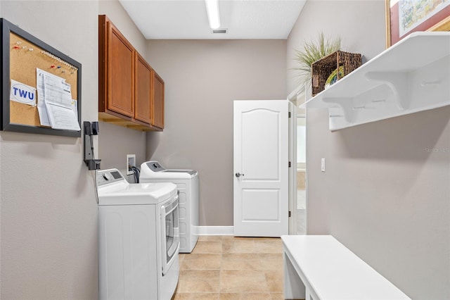 clothes washing area with visible vents, independent washer and dryer, cabinet space, and baseboards