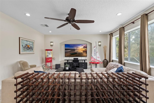 interior space featuring a textured ceiling, ceiling fan, visible vents, and recessed lighting