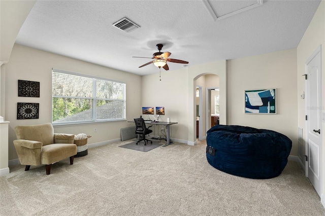 carpeted office space featuring baseboards, visible vents, arched walkways, and a textured ceiling