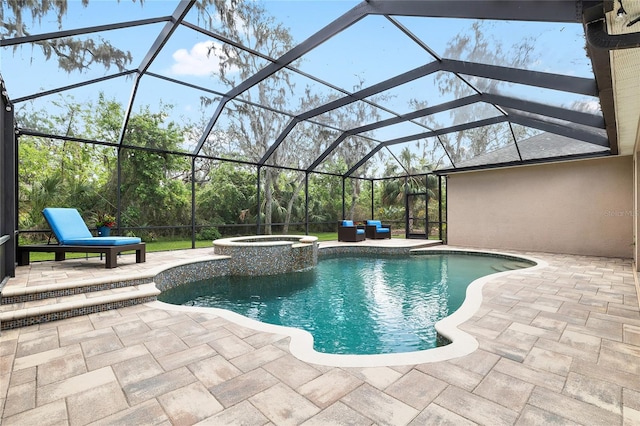 view of pool featuring glass enclosure, a pool with connected hot tub, and a patio area