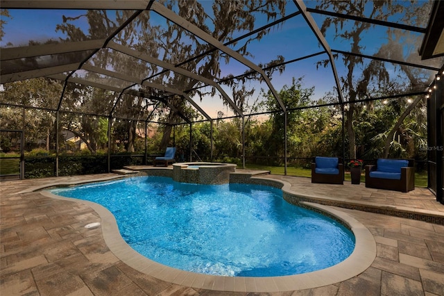 pool at dusk featuring a pool with connected hot tub, a patio, and a lanai