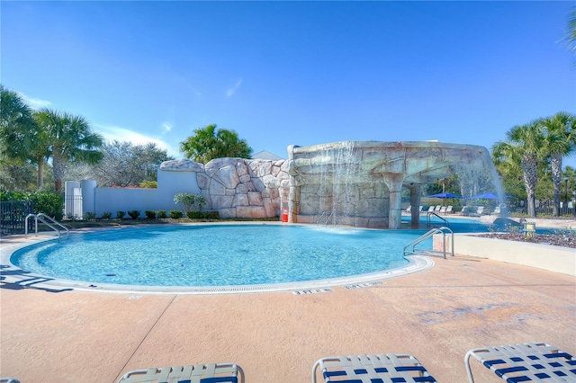 pool featuring fence and a patio