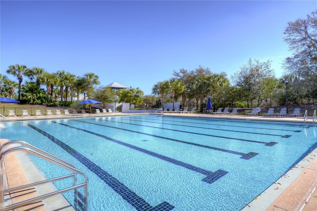 community pool with fence and a patio