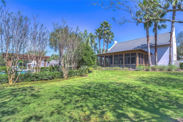 view of yard featuring a sunroom and a pergola