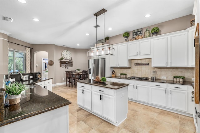 15912 Ternglade Dr, Lithia, FL 33547 - kitchen featuring appliances with stainless steel finishes, arched walkways, a center island, decorative backsplash, and recessed lighting