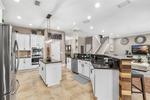 15912 Ternglade Dr, Lithia, FL 33547 - kitchen with stainless steel appliances, a large island with sink, a sink, tasteful backsplash, and white cabinets