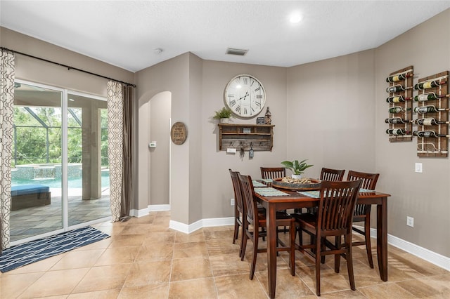 15912 Ternglade Dr, Lithia, FL 33547 - dining area with arched walkways, baseboards, light tile patterned floors, a textured ceiling, and recessed lighting