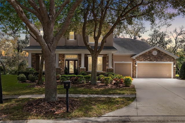 15912 Ternglade Dr, Lithia, FL 33547 - view of front of house featuring stone siding, concrete driveway, an attached garage, roof with shingles, and a lawn