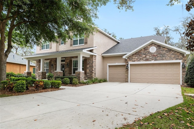 15912 Ternglade Dr, Lithia, FL 33547 - view of front facade with covered porch, stone siding, a garage, concrete driveway, and stucco siding