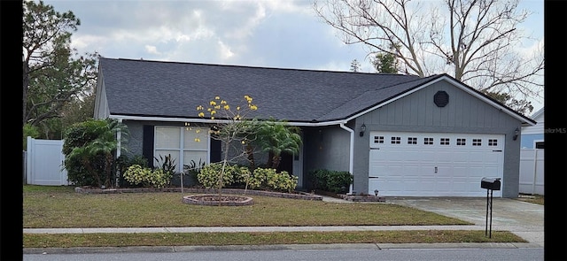 ranch-style house featuring a garage, concrete driveway, a front lawn, and a shingled roof