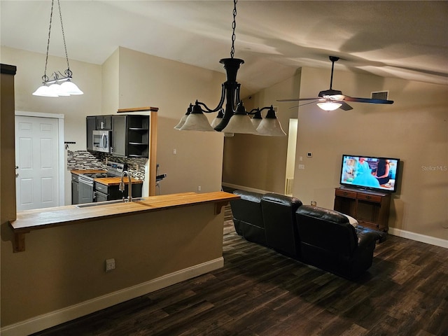 cinema room with dark wood-type flooring, vaulted ceiling, baseboards, and ceiling fan