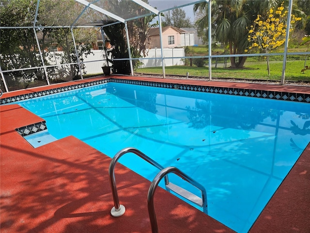 view of swimming pool with a fenced in pool, glass enclosure, a yard, and fence