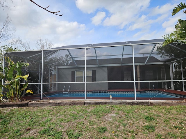 rear view of property with a lanai and an outdoor pool