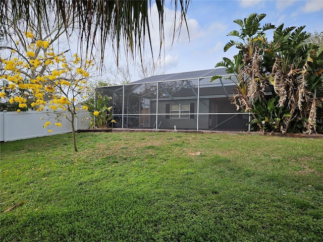 view of yard featuring glass enclosure and a fenced backyard