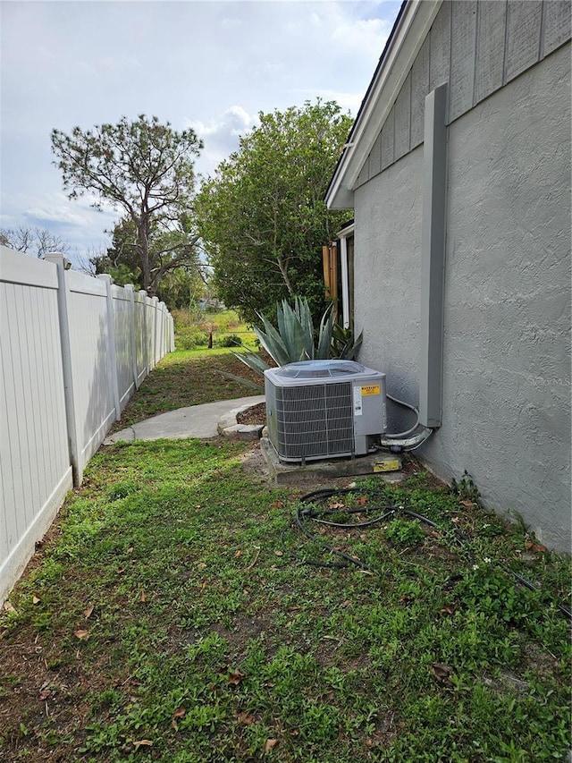 view of yard with fence and central air condition unit