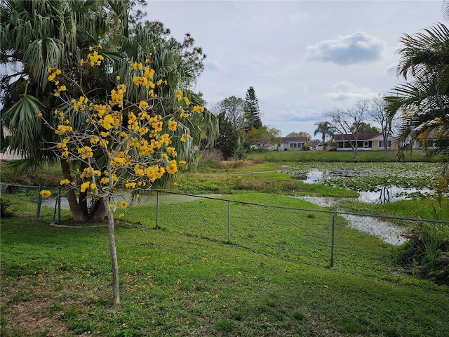 view of yard featuring a water view and fence