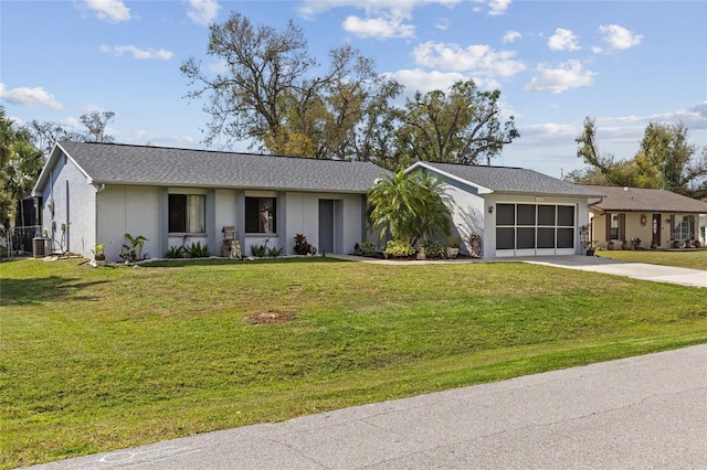 ranch-style home with an attached garage, driveway, a front lawn, and central AC unit