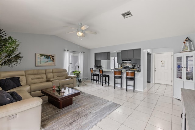 living room with a ceiling fan, visible vents, vaulted ceiling, and light tile patterned flooring