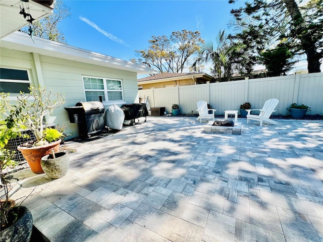 view of patio / terrace with an outdoor fire pit, a grill, and fence