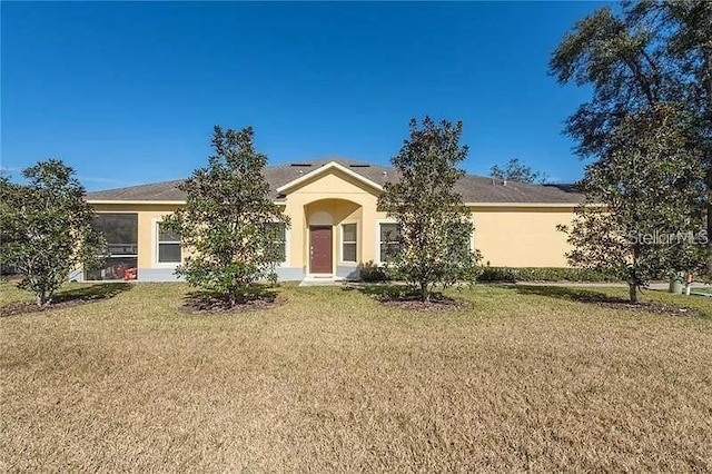 ranch-style house with a front lawn and stucco siding