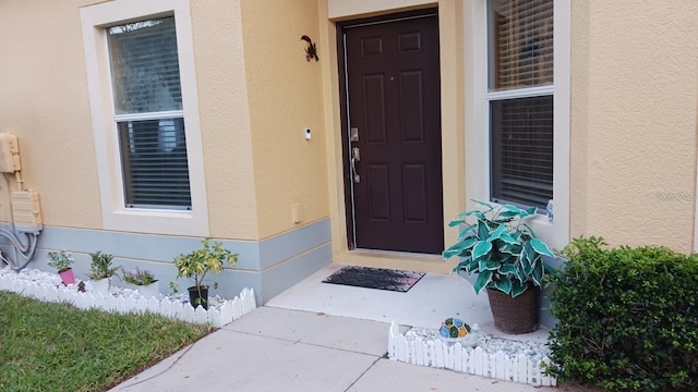 doorway to property featuring stucco siding