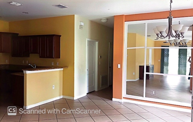 kitchen with light tile patterned flooring, a notable chandelier, visible vents, baseboards, and dark brown cabinets