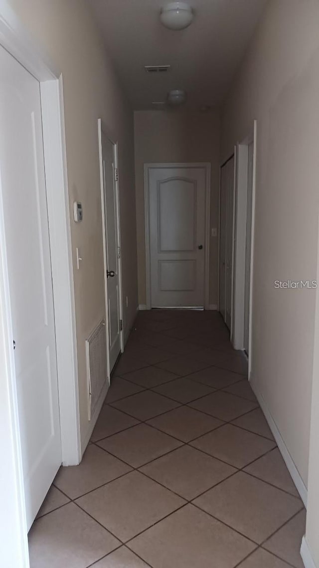 hall featuring visible vents and light tile patterned floors