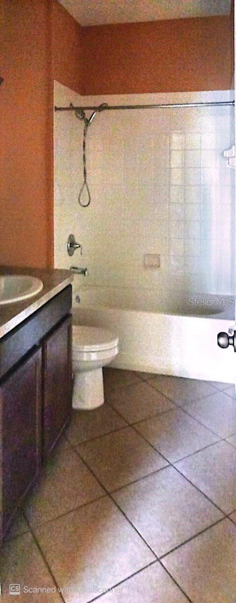 bathroom with toilet, vanity, shower / washtub combination, and tile patterned floors