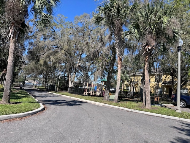 view of street with a gated entry and curbs