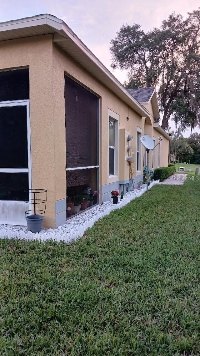 view of home's exterior featuring a yard and stucco siding