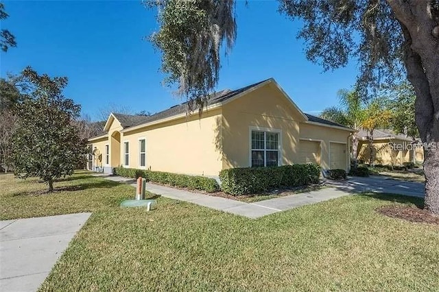 view of property exterior featuring a garage, a yard, and stucco siding