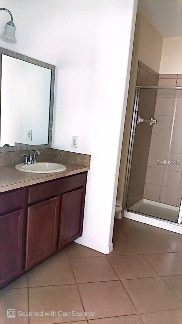 full bath with vanity, a shower stall, toilet, and tile patterned floors