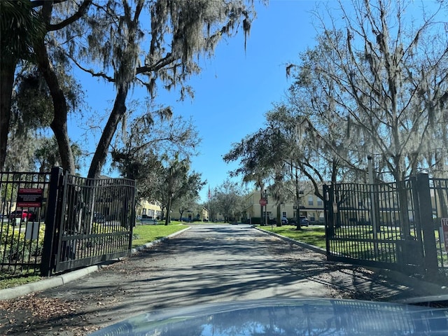 view of road with curbs, a gated entry, traffic signs, and a gate