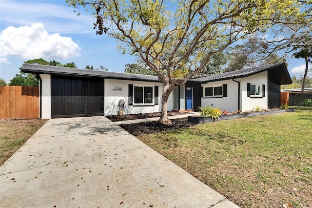 single story home featuring an attached garage, concrete driveway, a front yard, and fence