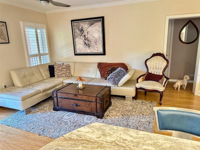 living room featuring baseboards, ceiling fan, ornamental molding, and wood finished floors