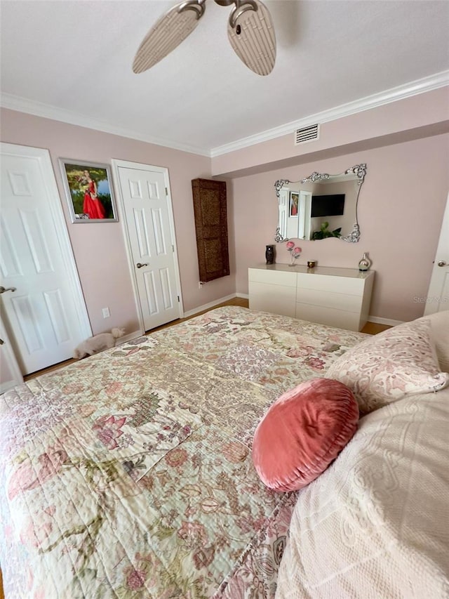 bedroom featuring a ceiling fan, visible vents, crown molding, and baseboards