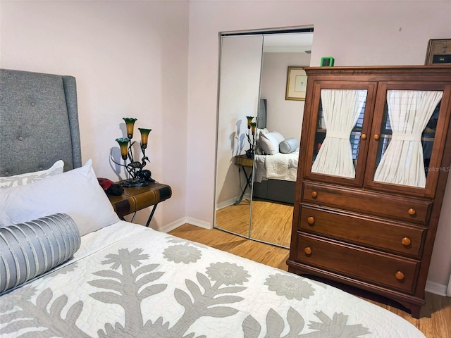 bedroom featuring a closet, baseboards, and wood finished floors