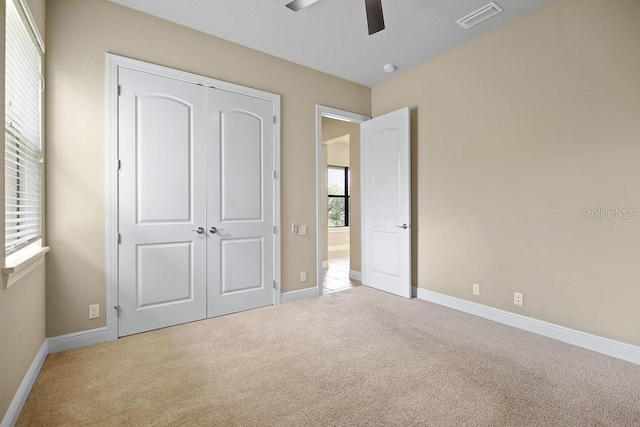 unfurnished bedroom with carpet, visible vents, a closet, and baseboards