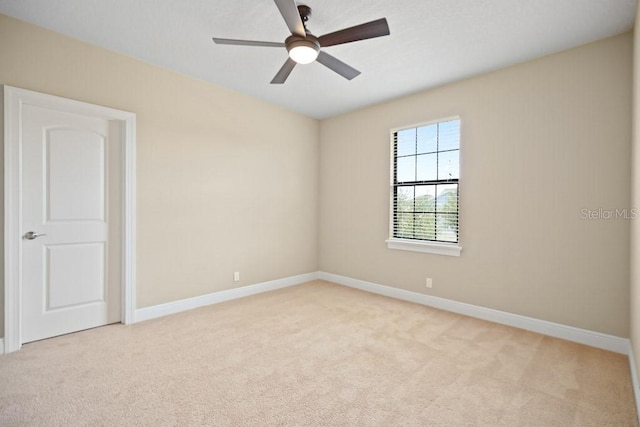 unfurnished room with light colored carpet, baseboards, and ceiling fan