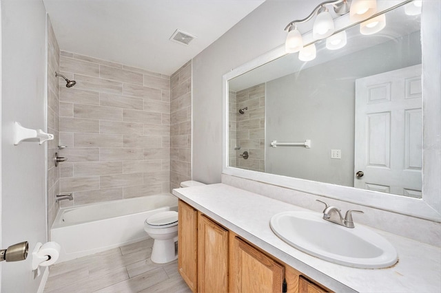 bathroom with toilet, shower / tub combination, visible vents, and vanity