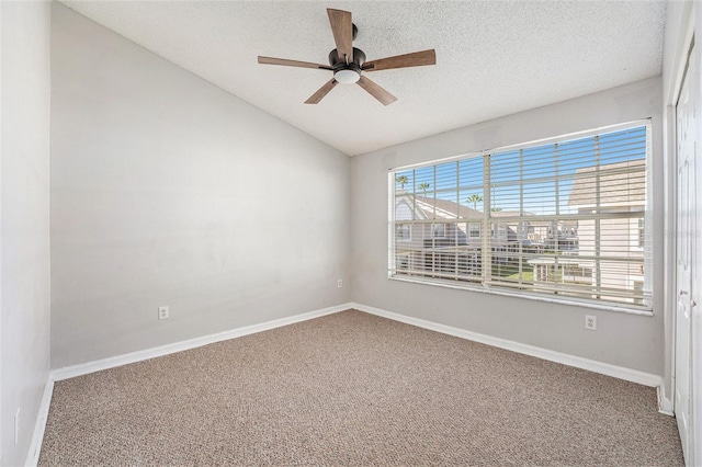 spare room featuring carpet, vaulted ceiling, a textured ceiling, and baseboards