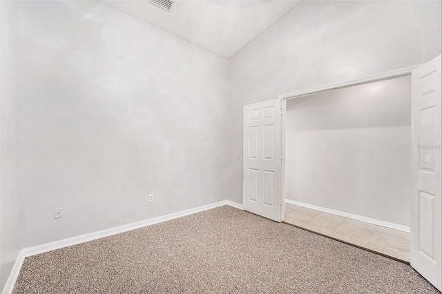 interior space with vaulted ceiling, tile patterned flooring, and baseboards