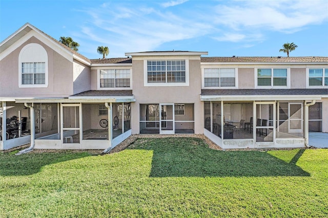 back of house with a sunroom, a lawn, and stucco siding