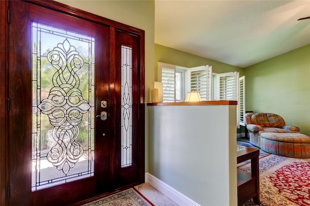 foyer with vaulted ceiling and baseboards